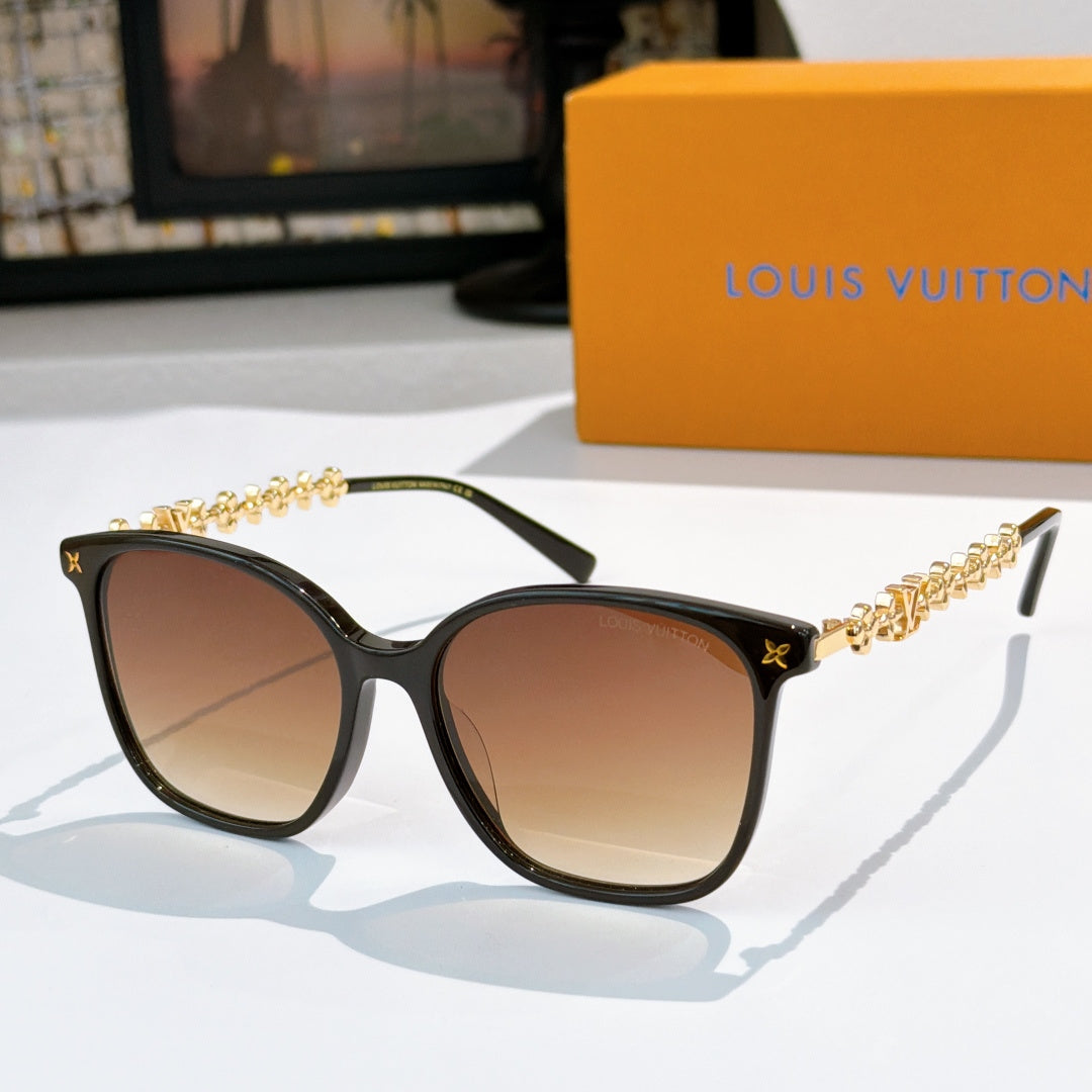 Louis Vuitton sunglasses with black frames, gold chain temples, tan gradient tinted lenses