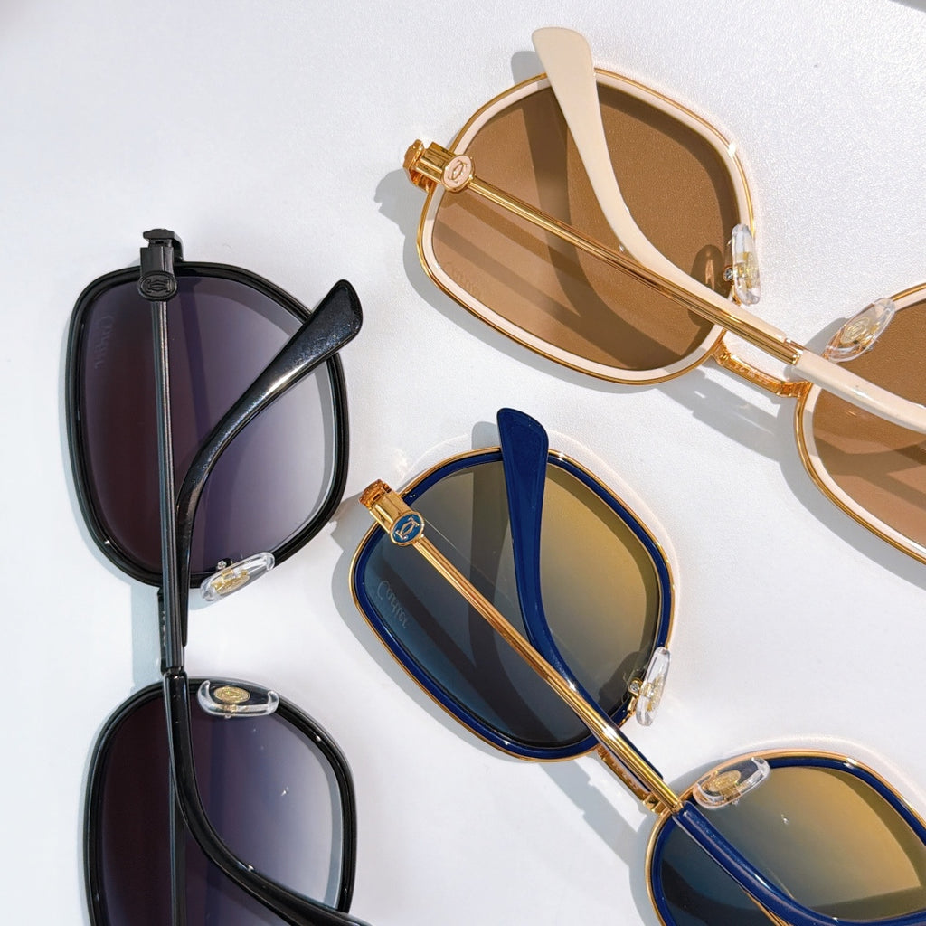 Two pairs of Cartier sunglasses with dark lenses in black and blue frames