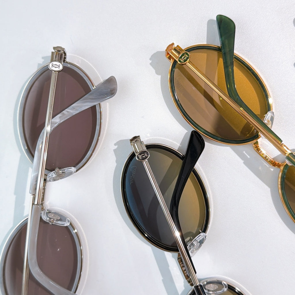 Close-up of round sunglasses lenses and frames: dark, brown, and gold-tone.