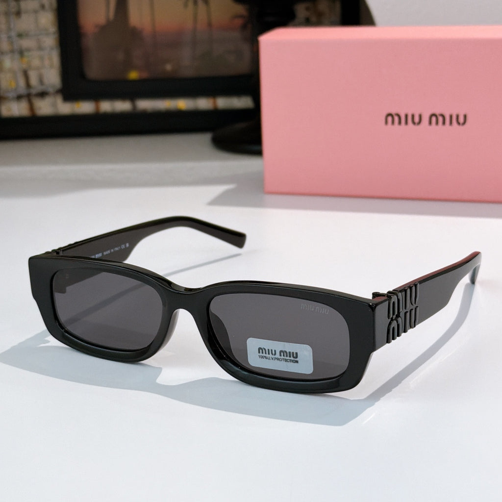 MiuMiu black oversized sunglasses with gray lenses and gold logo temple detail