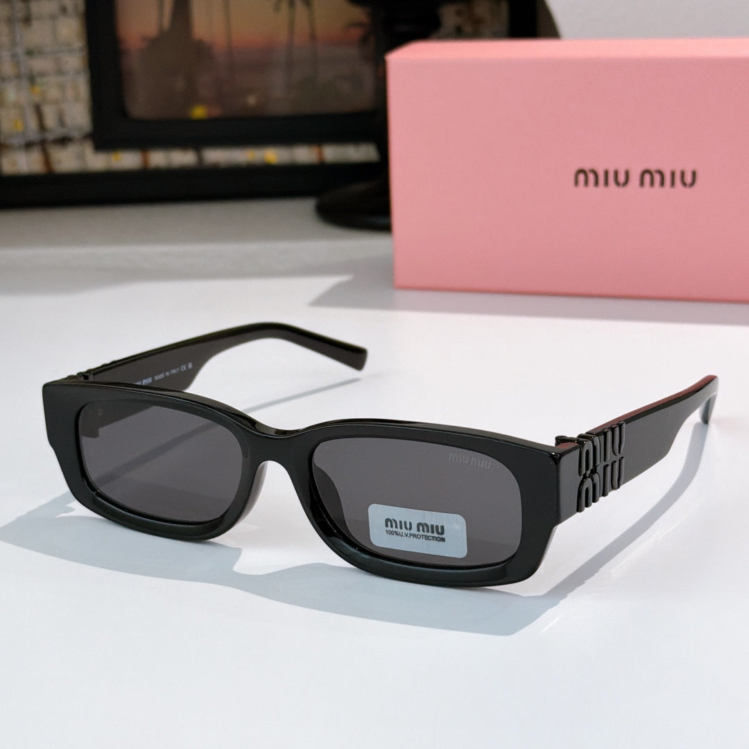 MiuMiu black oversized sunglasses with gray lenses and gold logo temple detail