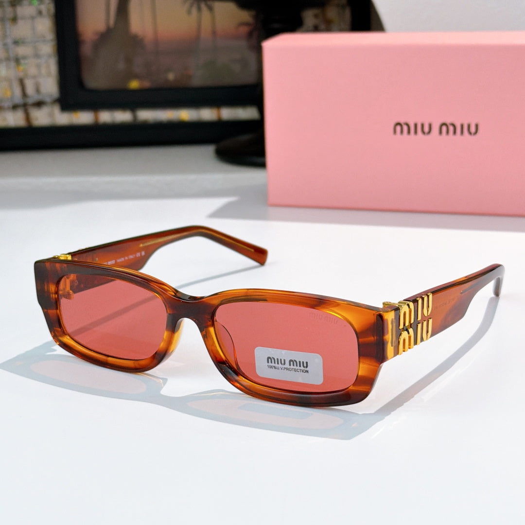 MiuMiu tortoiseshell oversized sunglasses with red-tinted lenses and gold logo temple
