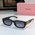 MiuMiu black oversized sunglasses with dark lenses and gold logo temple detail