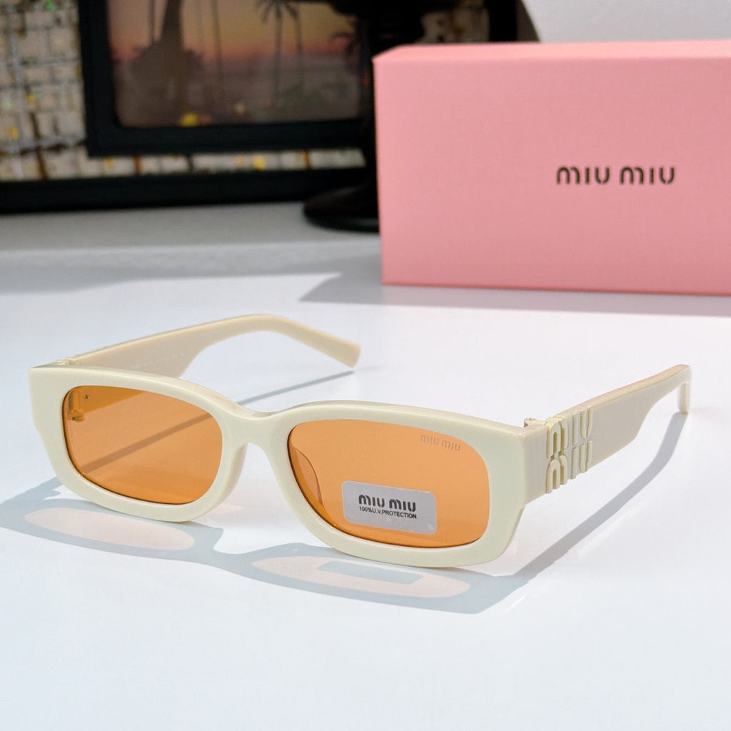 MiuMiu cream oversized sunglasses with amber-tinted lenses and gold logo temple
