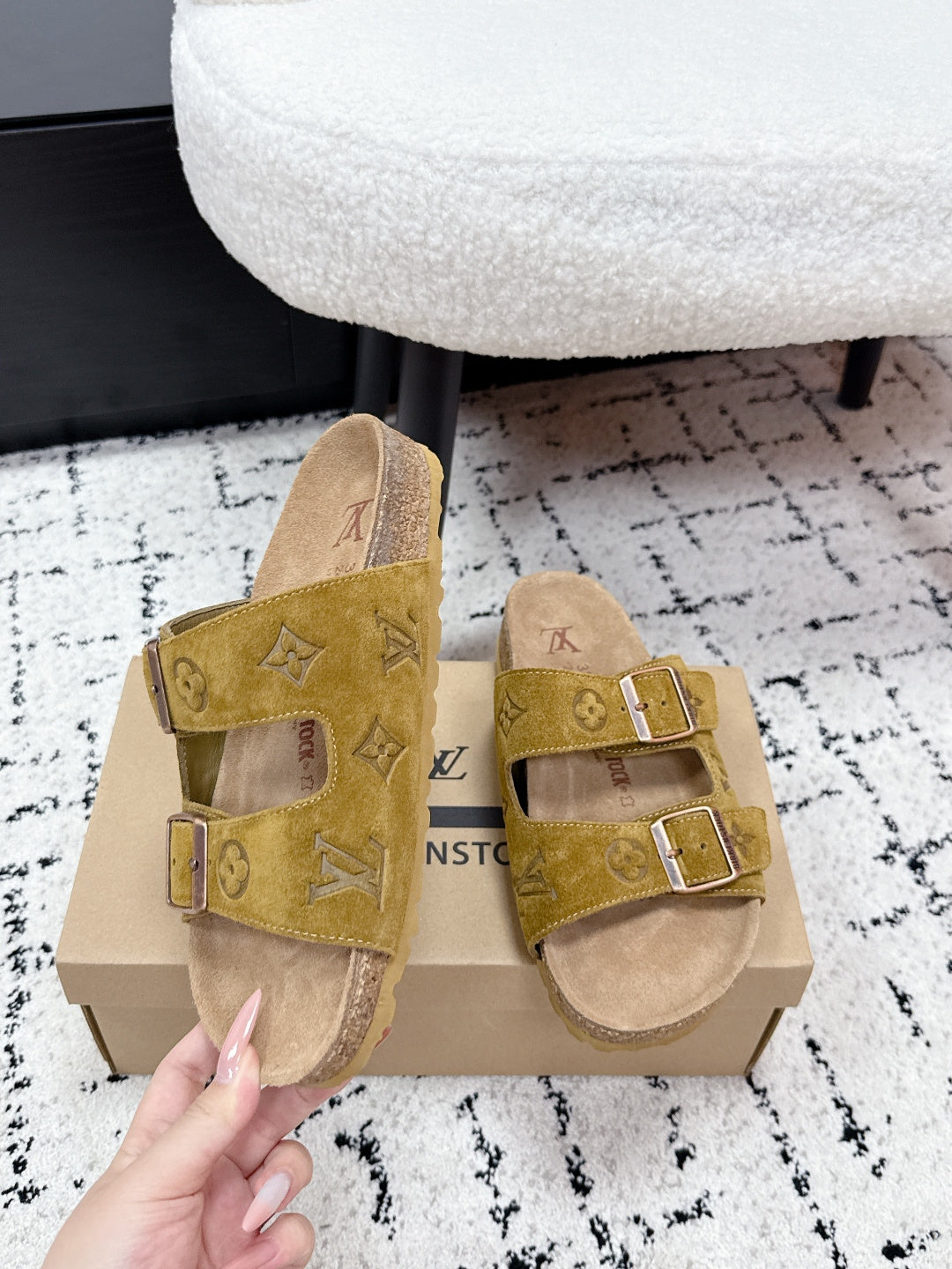 Louis Vuitton mustard sandals with buckled double straps, held above shoe box