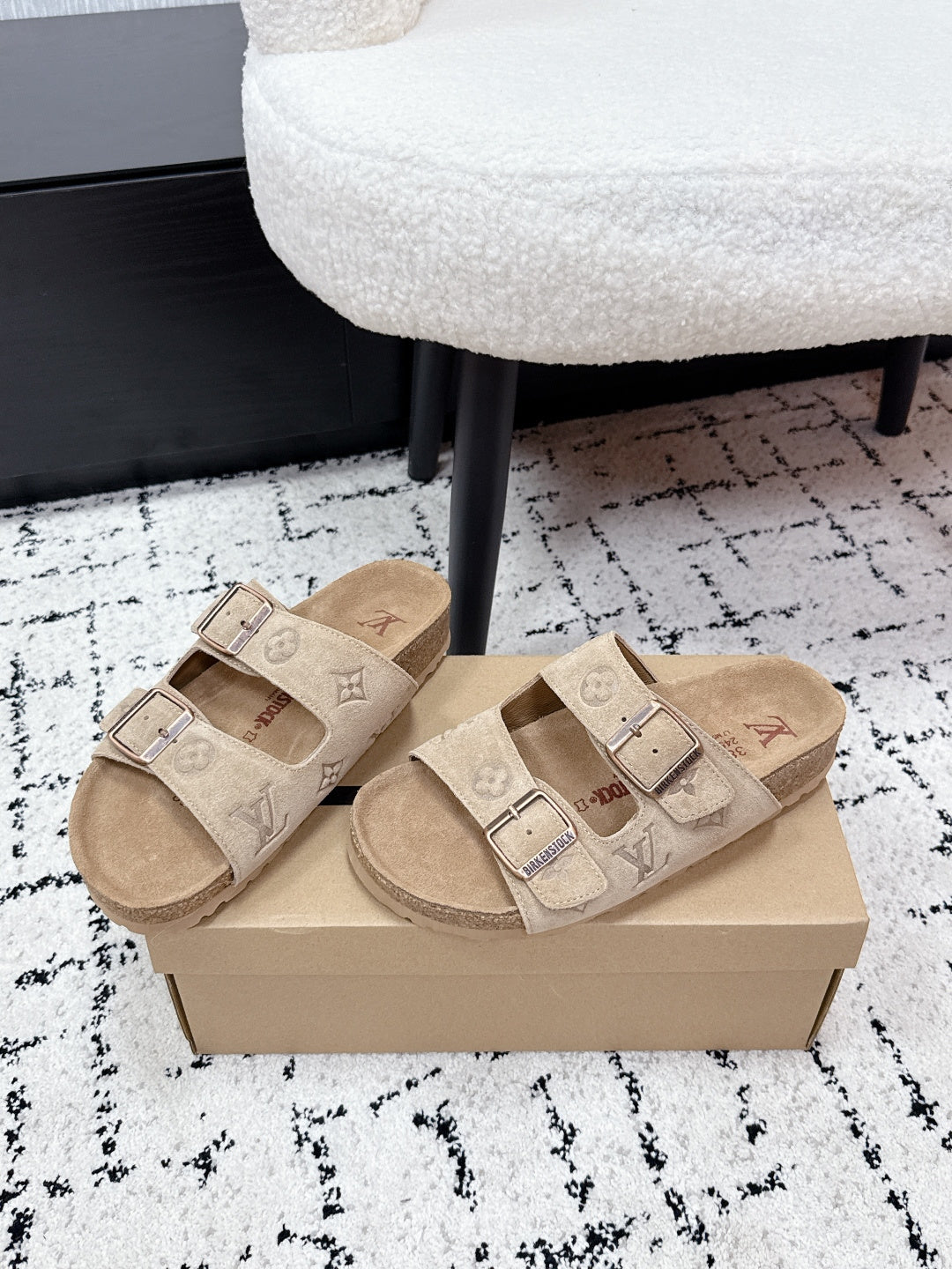 Beige Louis Vuitton slide sandals with two buckle straps and cushioned footbed.