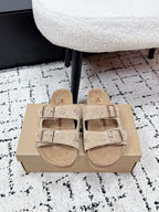 Beige Louis Vuitton slide sandals with two adjustable buckle straps and logo-pattern footbed.