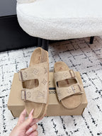 Beige Louis Vuitton slide sandals with adjustable buckles and logo-printed straps.