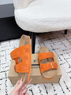 Orange slide sandals with two buckled straps and tan lining