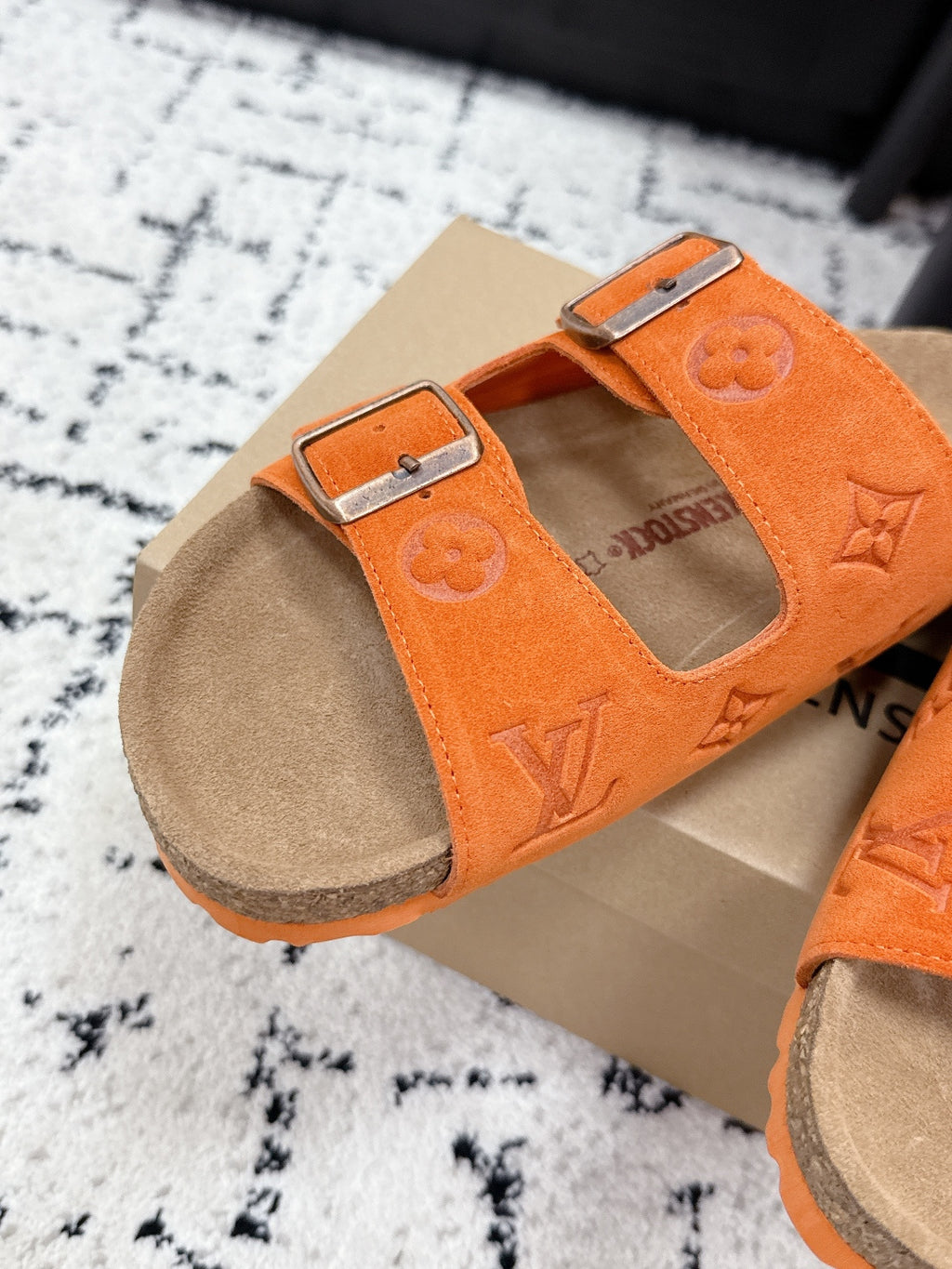 Orange slide sandal with double straps and silver buckles, tan footbed