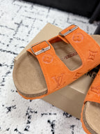 Orange slide sandal with double straps and silver buckles, tan footbed