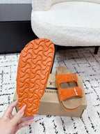 Orange slide sandal outsole with patterned tread and tan footbed
