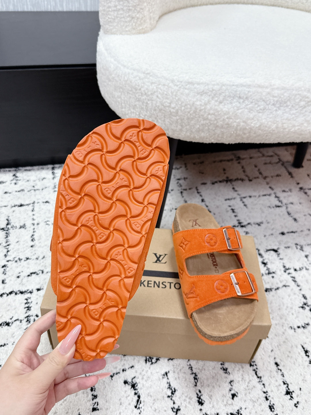 Orange slide sandal outsole with patterned tread and tan footbed