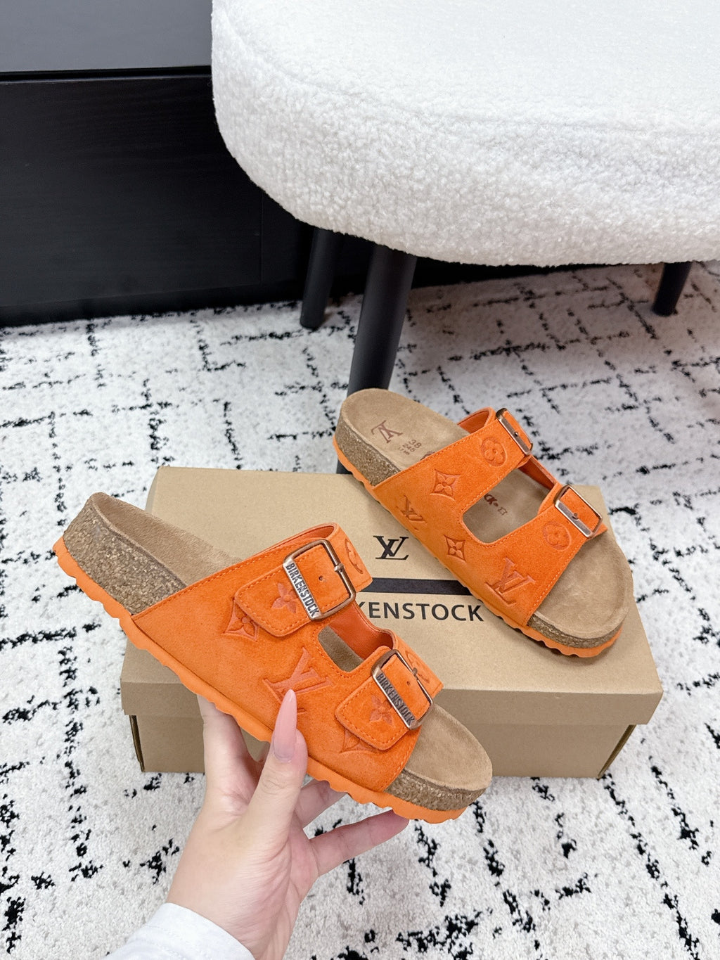Orange slide sandals with two straps, silver buckles, and tan cork sole