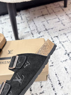 Louis Vuitton slide sandal side view, black suede with patterned straps and silver buckles