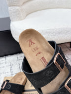Louis Vuitton slide sandal close-up, black upper with tan insole and buckle strap