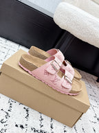 Louis Vuitton pink sandals with patterned double straps and metal buckles, side view
