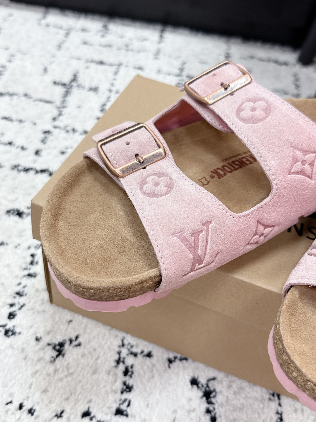 Louis Vuitton pink slide sandals with two buckled straps and monogram pattern, angled