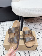Louis Vuitton monogram slide sandals with adjustable buckles, top straps view.