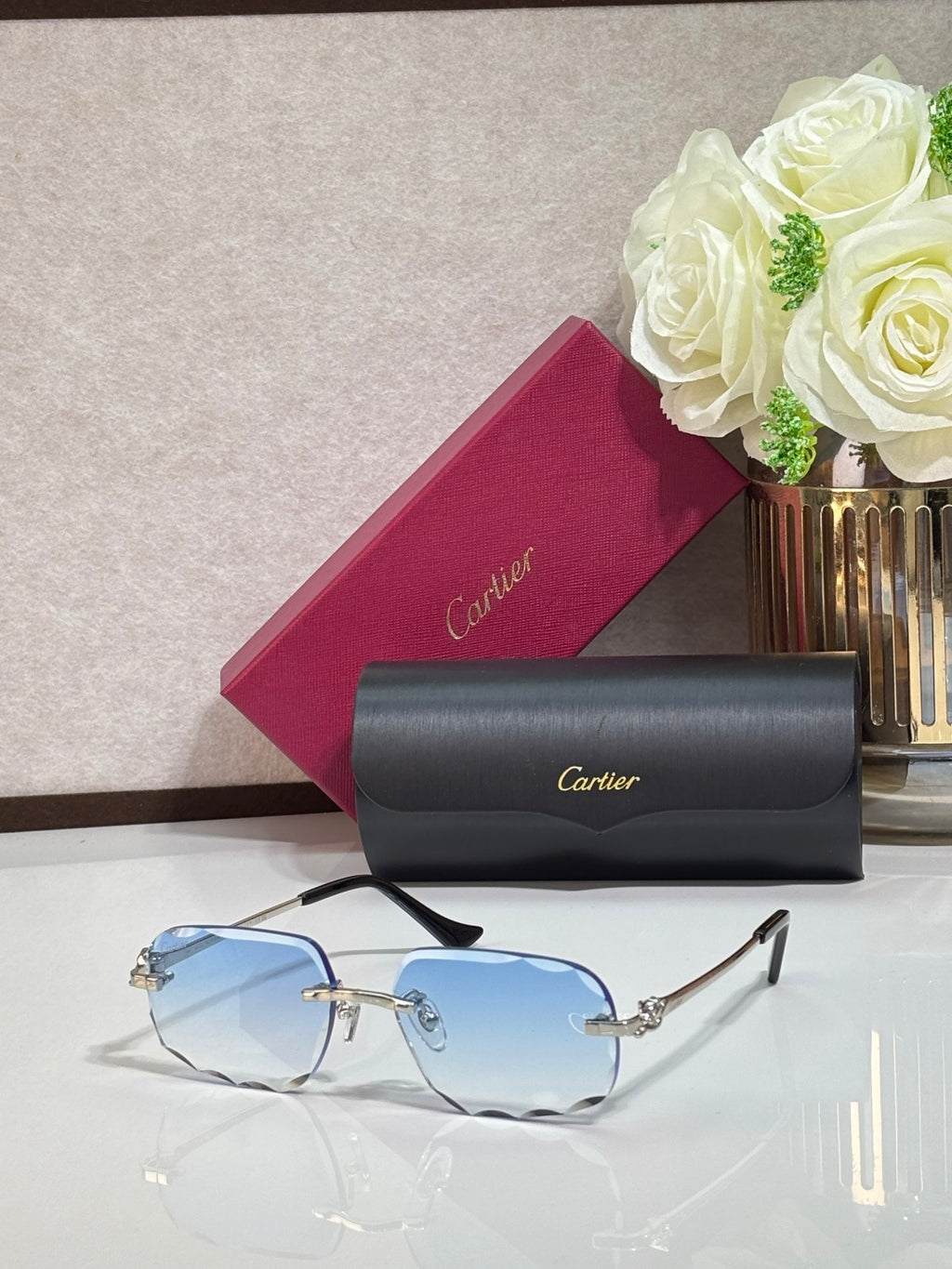 Rectangular gold-tone Cartier eyeglass frame with blue-tinted lenses and black temples