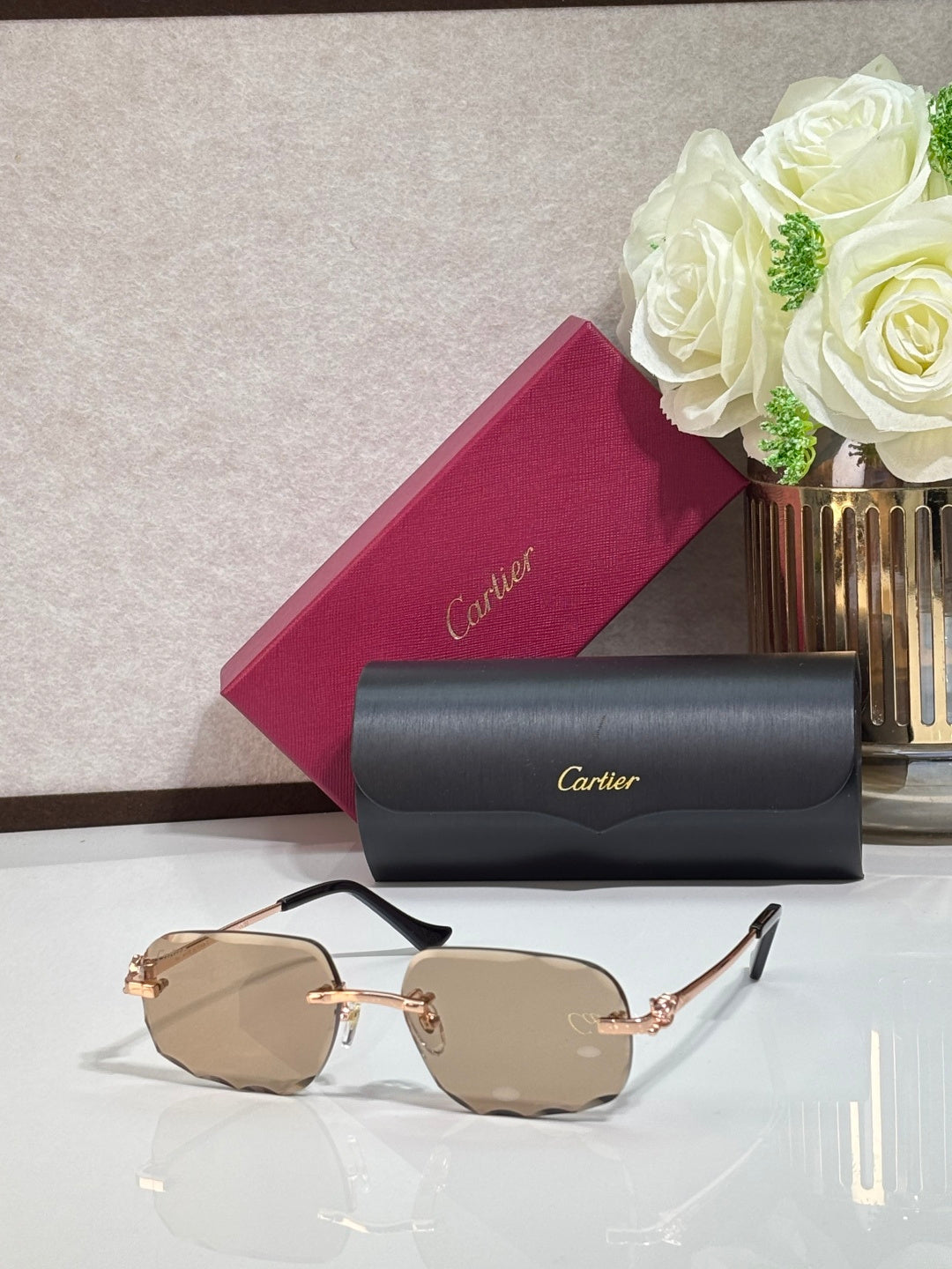 Rectangular gold-tone Cartier eyeglass frame with light tan lenses and black temples