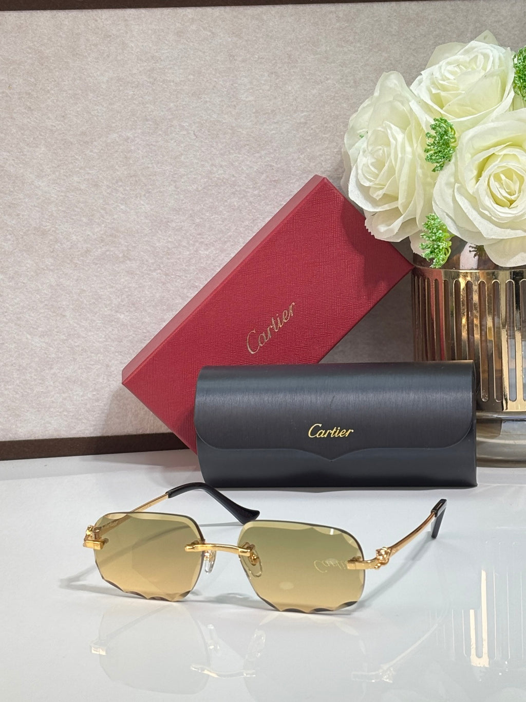Rectangular gold-tone Cartier eyeglass frame with amber-tinted lenses and black temples