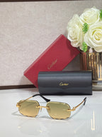 Rectangular gold-tone Cartier eyeglass frame with amber-tinted lenses and black temples