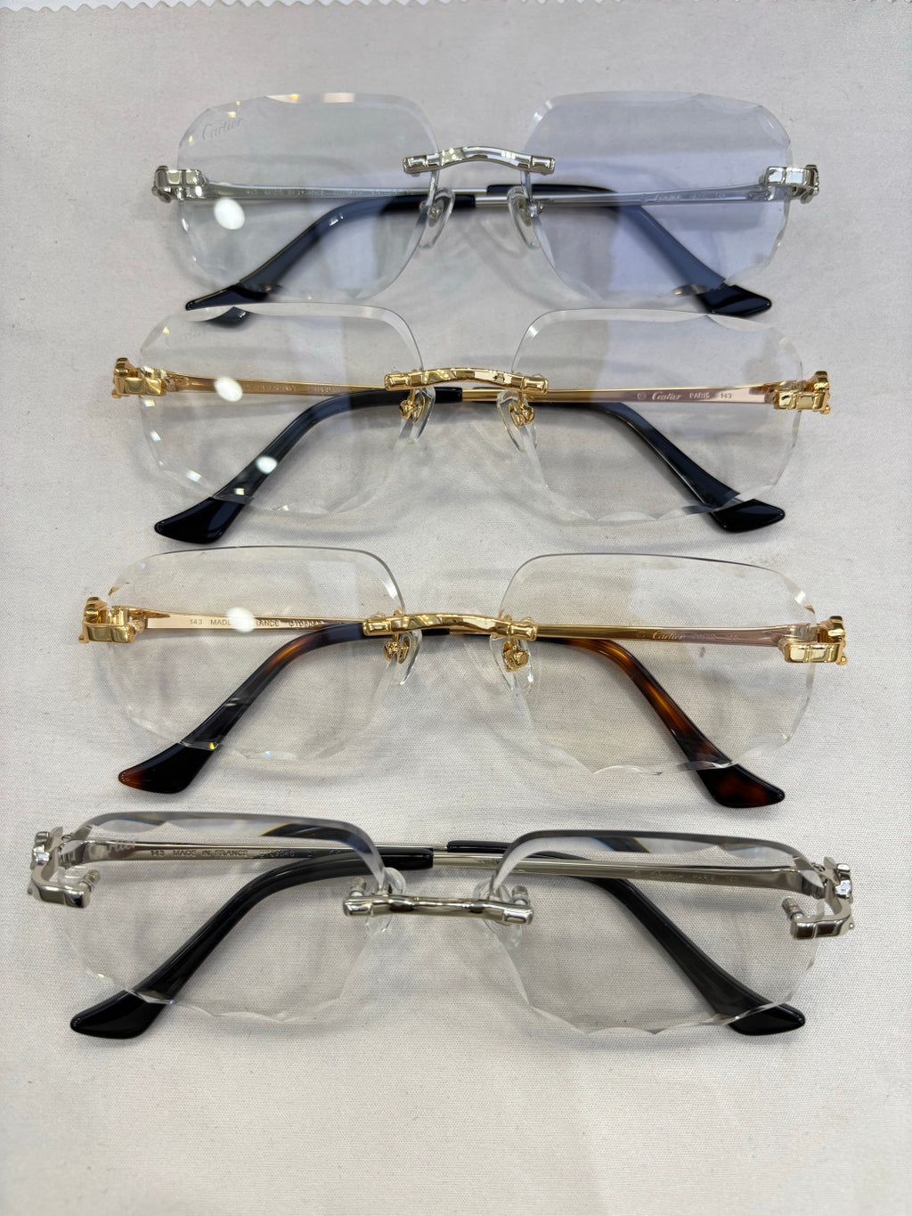 Set of Cartier eyeglass frames with clear and blue-tinted lenses and metal temple arms