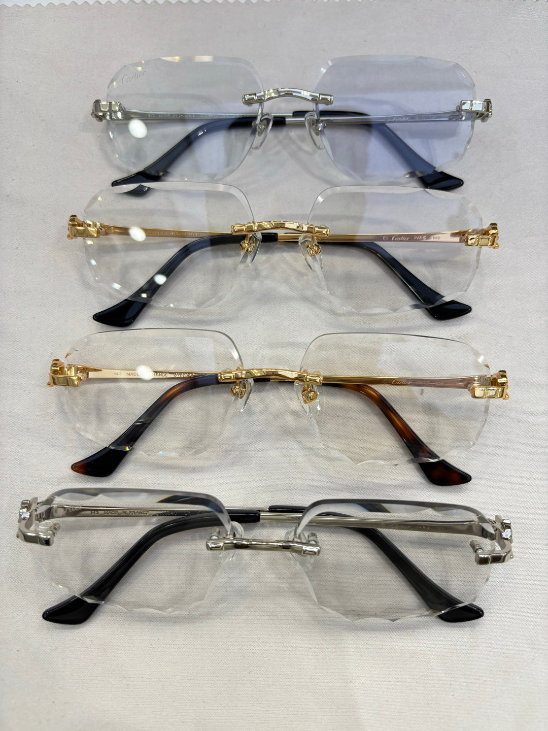 Set of Cartier eyeglass frames with clear and blue-tinted lenses and metal temple arms