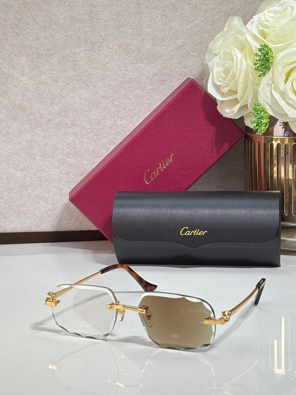 Cartier eyeglasses with gold rectangular frames and amber-tinted lenses, dark temple tips