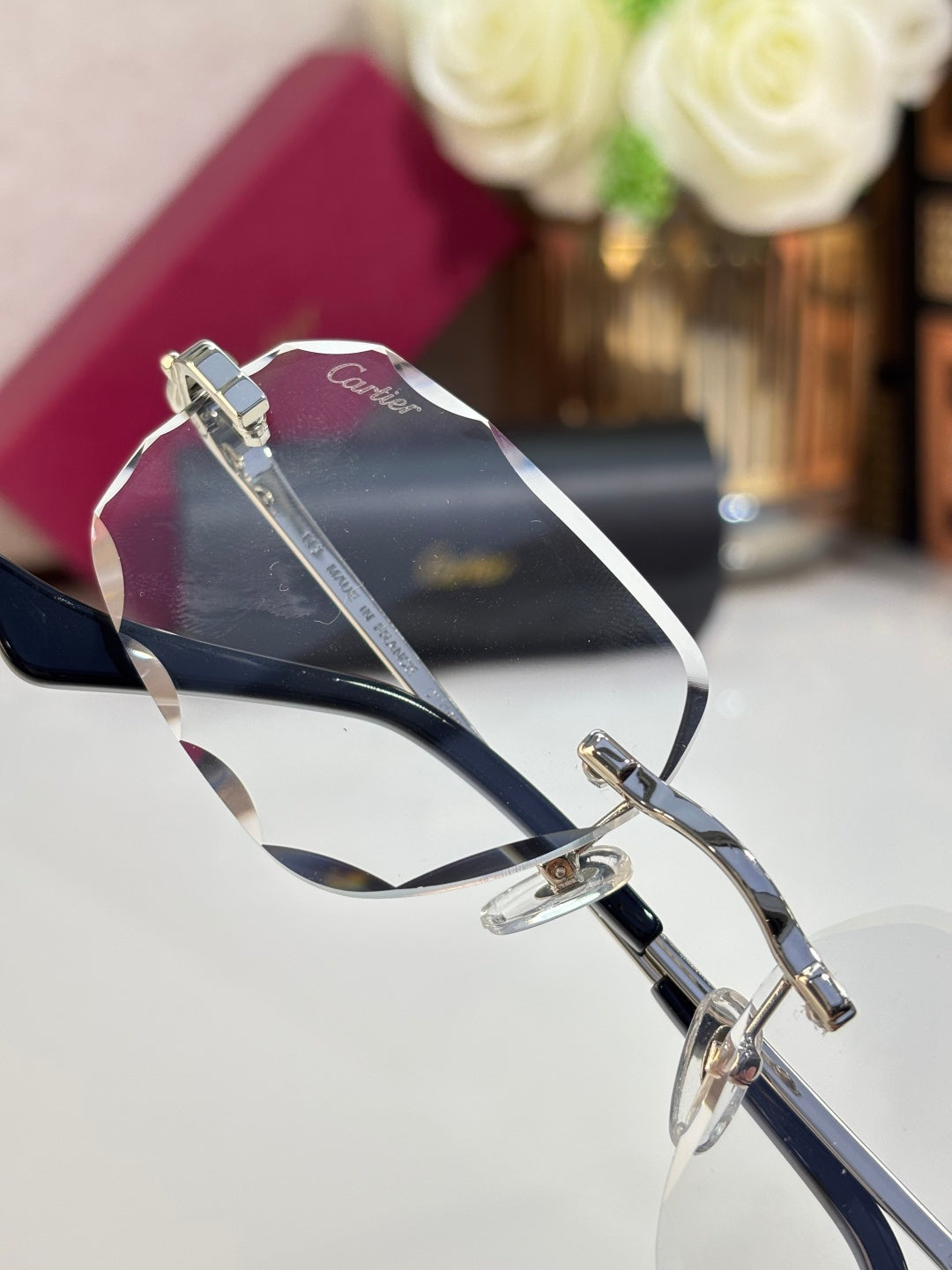 Cartier eyeglass frame with silver metal links and dark temple tips, blue-tinted lenses