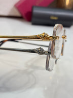 Cartier eyeglass frame close-up with gold emblem hinge and clear lens