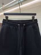Dark drawstring shorts with ribbed waistband and small embroidered logo