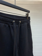 Dark drawstring shorts with ribbed waistband, drawcord, and small logo