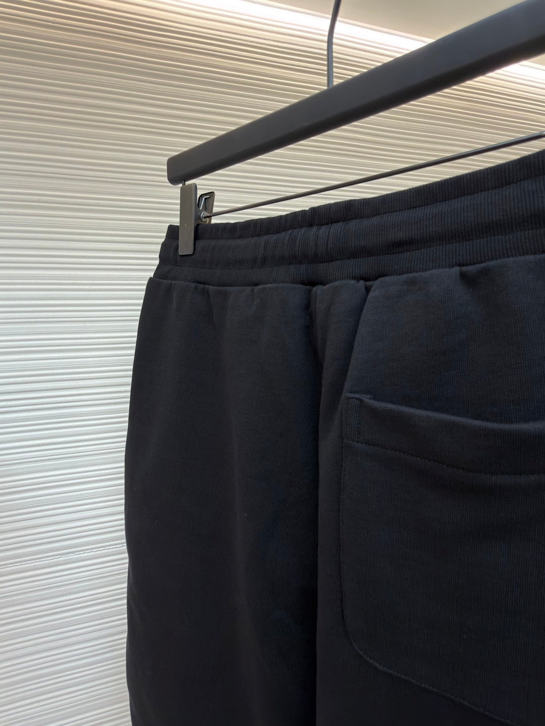 Dark shorts with elastic waistband, front pocket, and drawcord detail