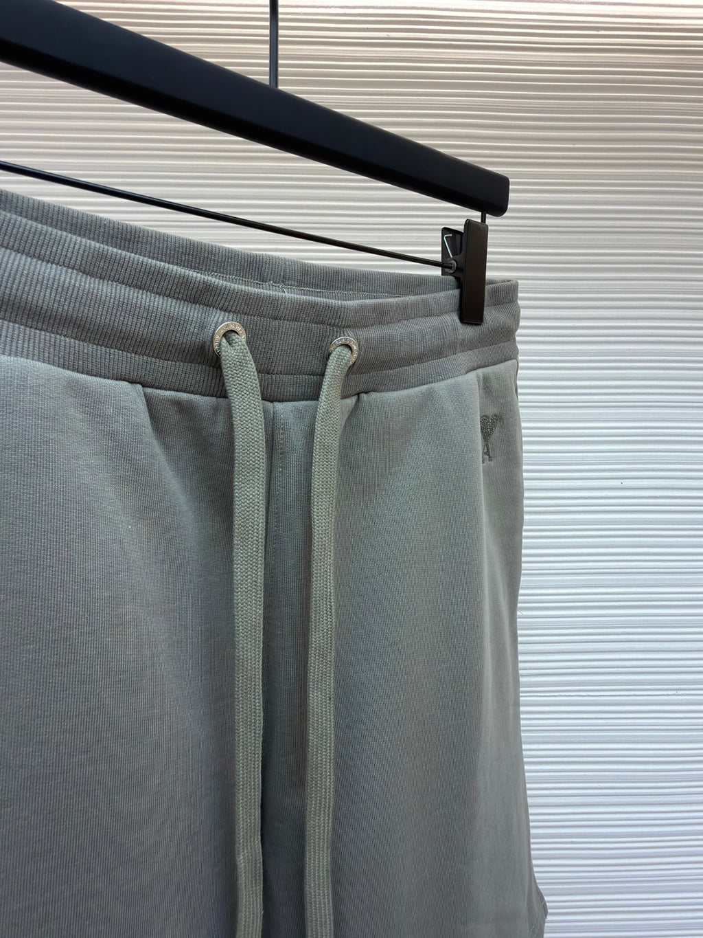 Amiri shorts top view, light gray with drawstring ties and elastic waistband