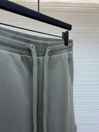 Amiri shorts top view, light gray with drawstring ties and elastic waistband