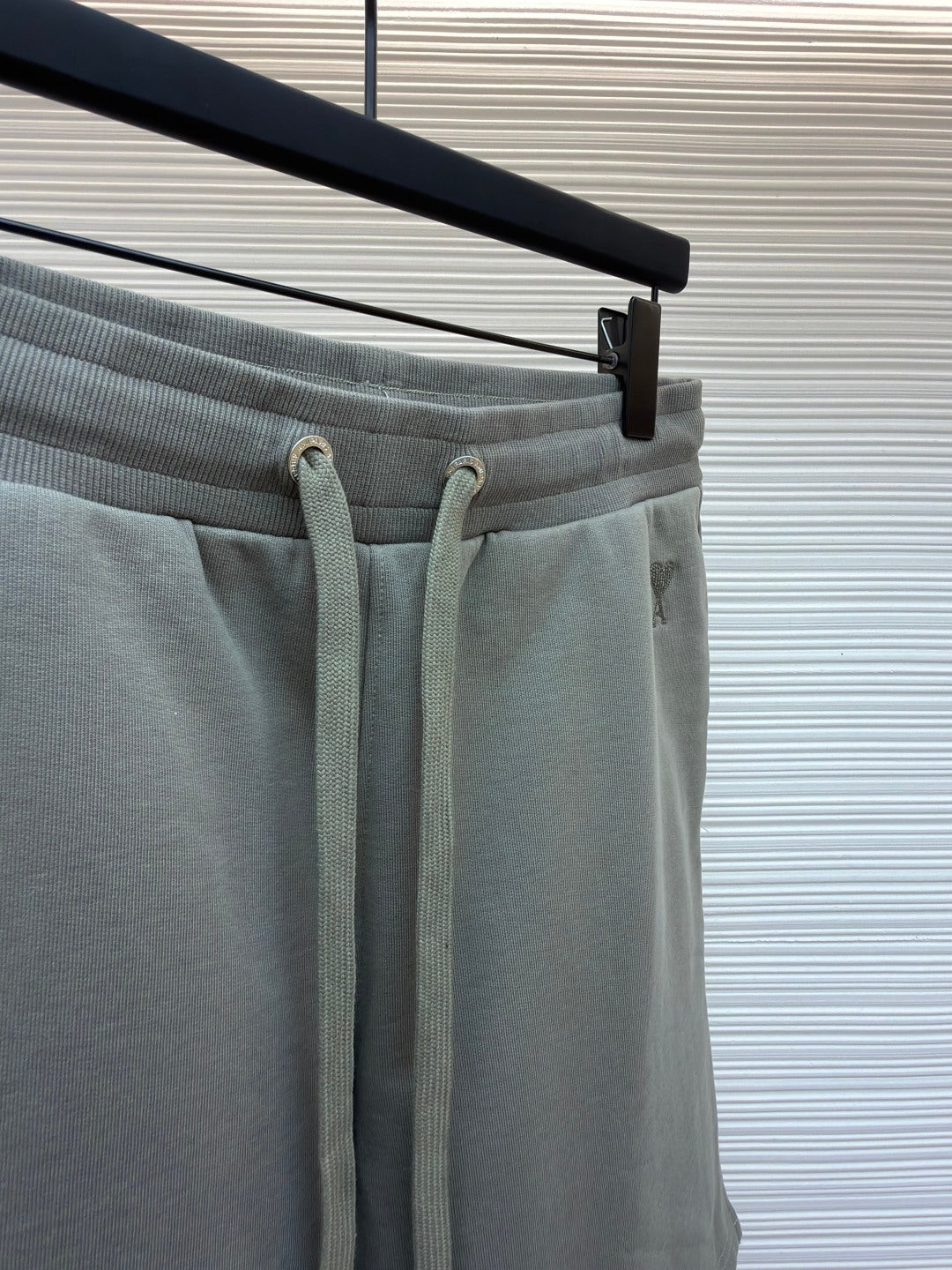 Amiri shorts top view, light gray with drawstring ties and elastic waistband