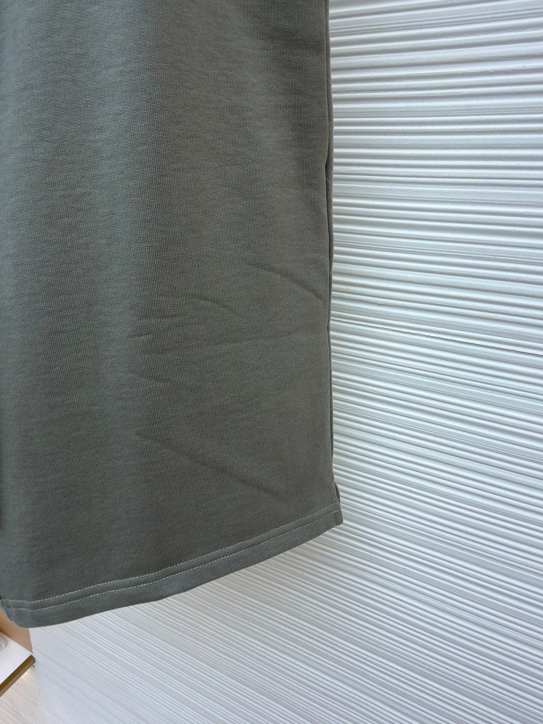 Amiri shorts side view, light gray with clean hem and fabric drape