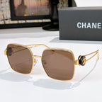 Chanel gold-tone sunglasses with brown-tinted square lenses and black-and-gold temple hardware.