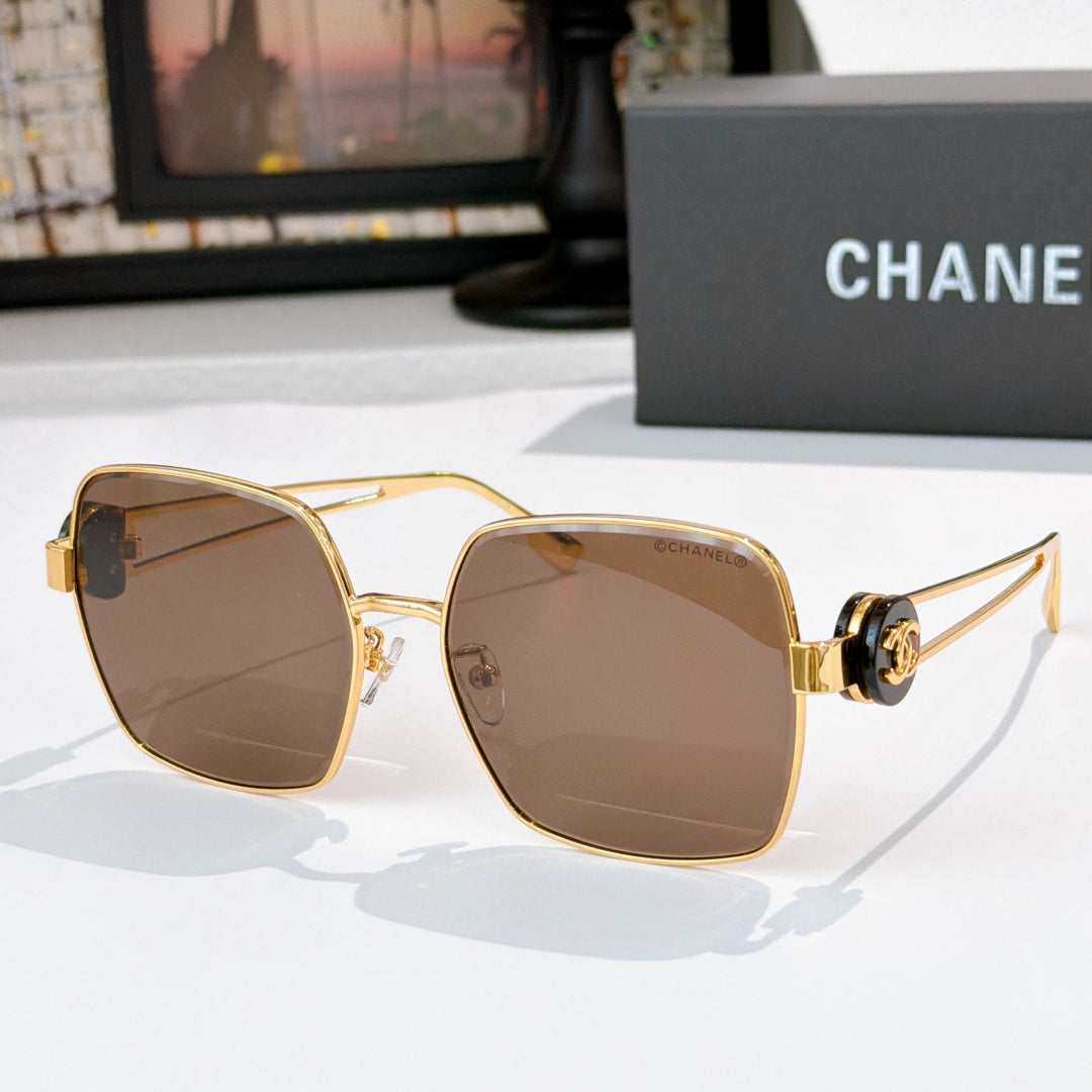 Chanel gold-tone sunglasses with brown-tinted square lenses and black-and-gold temple hardware.
