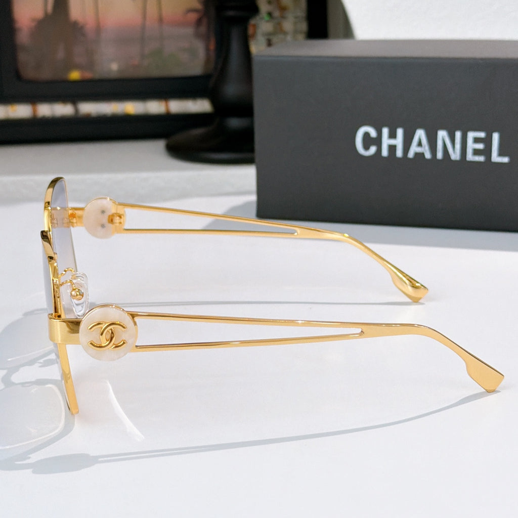 Chanel gold-tone sunglasses side profile with round logo emblem and tinted square lenses.