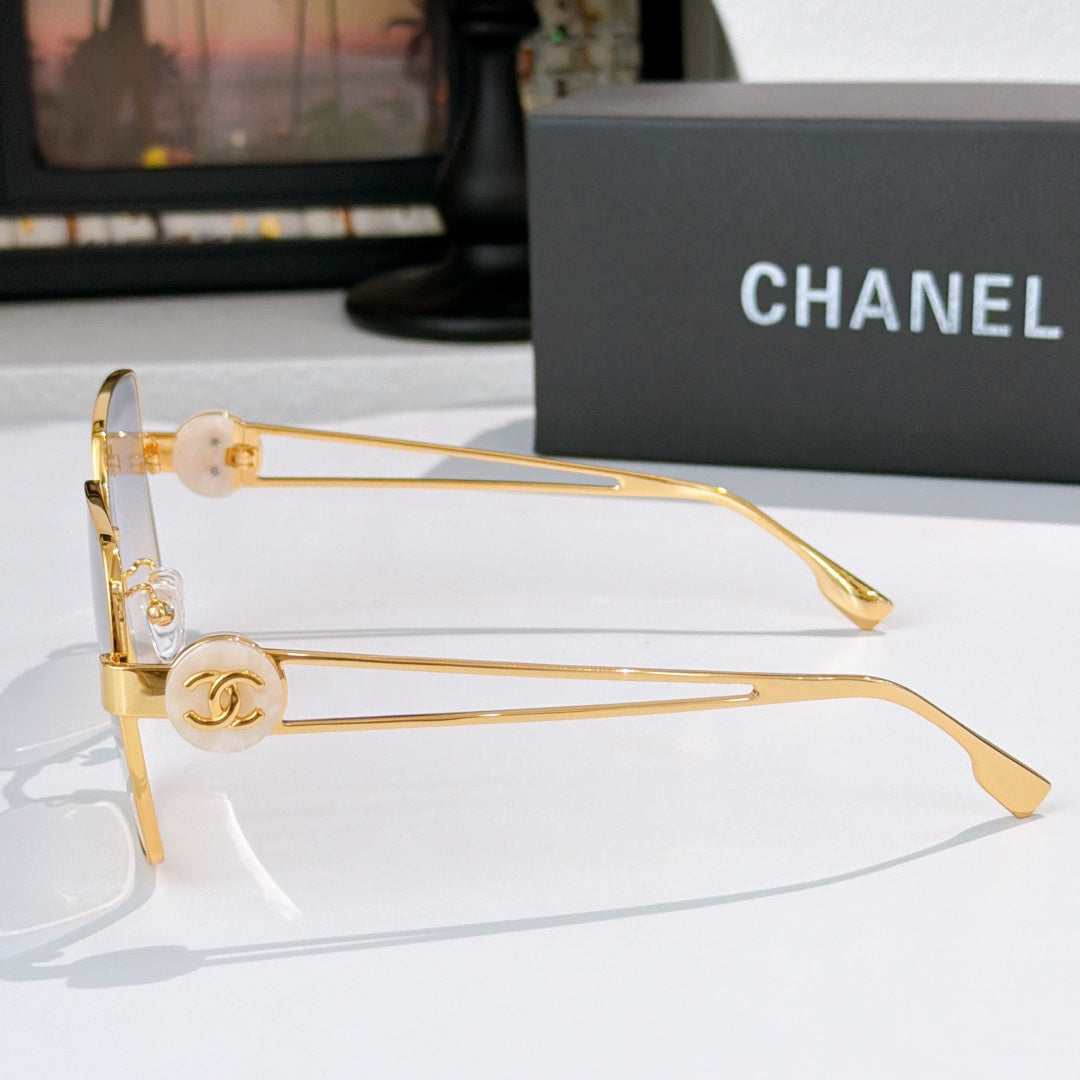 Chanel gold-tone sunglasses side profile with round logo emblem and tinted square lenses.