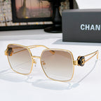 Chanel gold-tone sunglasses with light beige square lenses and logo hinge detail.