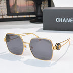 Chanel gold-tone sunglasses with dark gray square lenses and logo detail on temples.