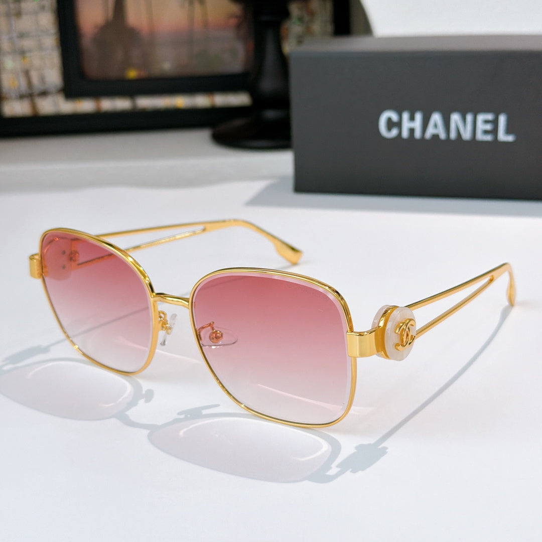 Gold-frame sunglasses with pink tinted lenses and curved cat-eye shape