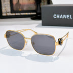 Gold-frame sunglasses with cool gray tinted lenses and bold rounded lenses