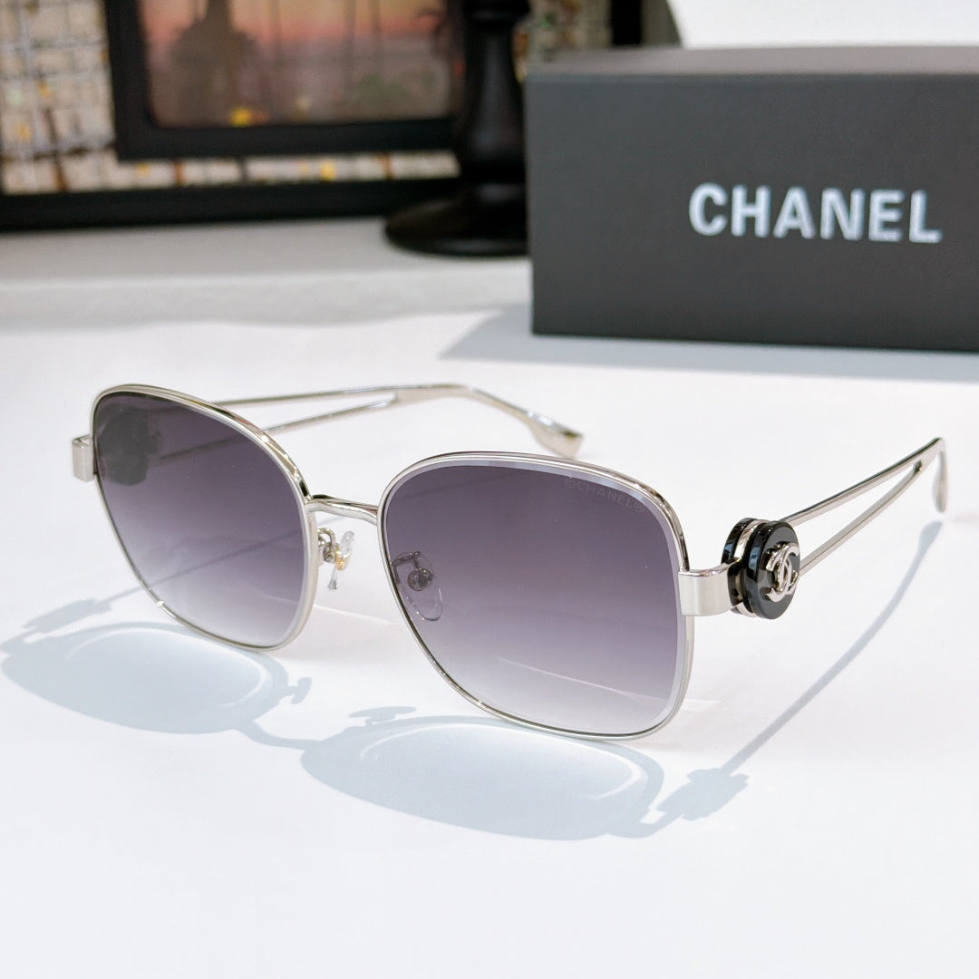 Silver-frame sunglasses with dark violet tinted lenses and rounded cat-eye shape