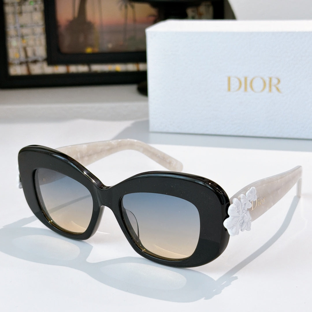 Dior sunglasses with black frames and light-tinted lenses, featuring a white floral temple detail