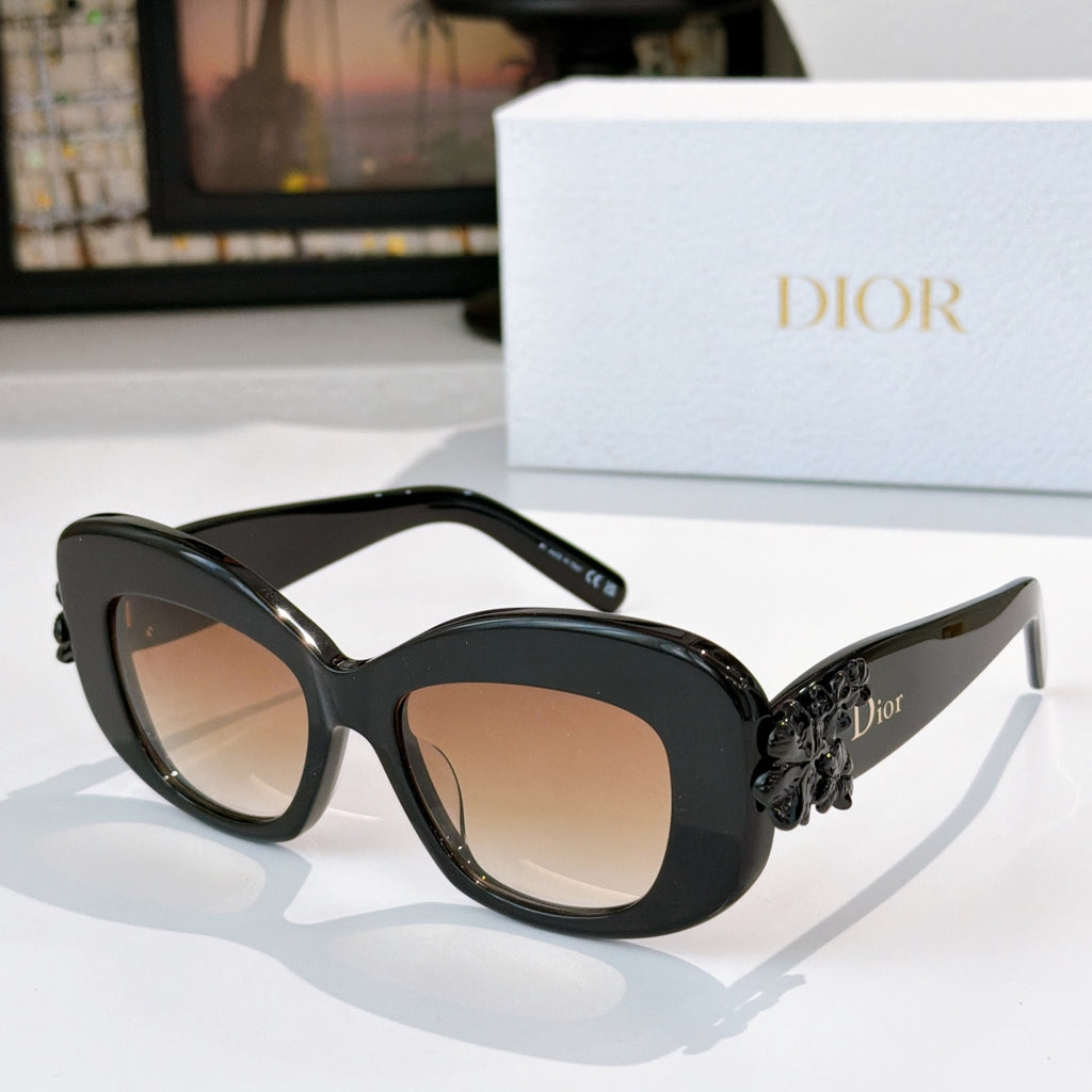 Dior sunglasses with black frames, tinted lenses, and sculpted floral detail at temples